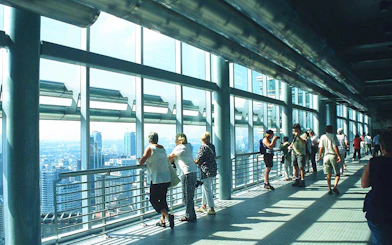 Visitors on the Petronas Twin Towers skybridge, Kuala Lumpur, enjoying city views.