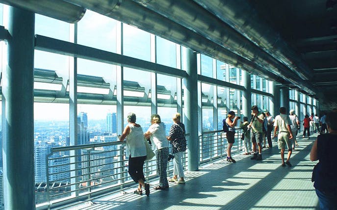 Visitors on the Petronas Twin Towers skybridge, Kuala Lumpur, enjoying city views.