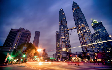Petronas Twin Towers illuminated at dusk, Kuala Lumpur cityscape.