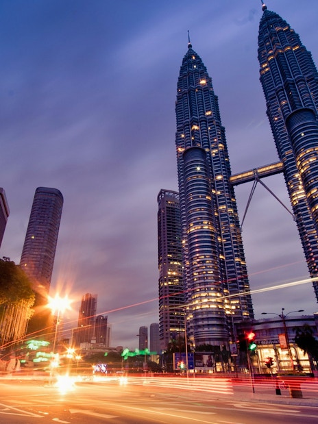 Petronas Twin Towers illuminated at dusk, Kuala Lumpur cityscape.