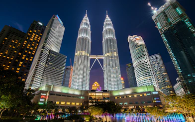 Petronas Twin Towers illuminated at night, Kuala Lumpur cityscape.