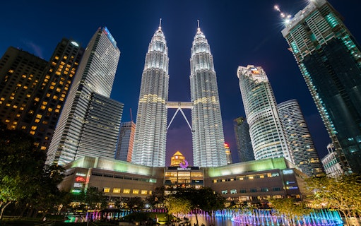 Petronas Twin Towers illuminated at night, Kuala Lumpur cityscape.
