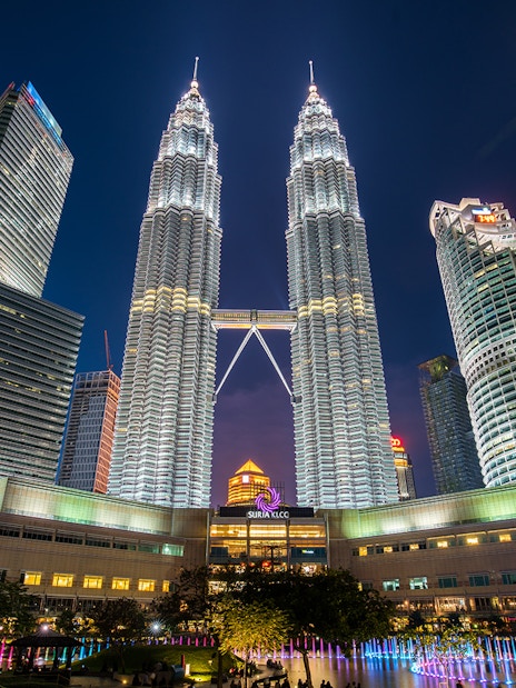 Petronas Twin Towers illuminated at night, Kuala Lumpur cityscape.