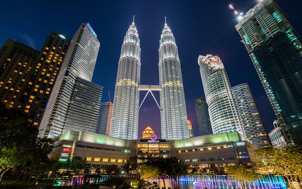 Petronas Twin Towers illuminated at night, Kuala Lumpur cityscape.