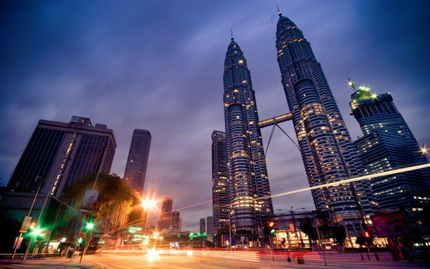 Petronas Twin Towers illuminated at dusk in Kuala Lumpur, Malaysia.