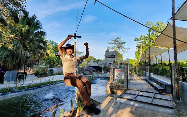 Man ziplining over crocodile enclosure at Crocodile Adventureland Langkawi.