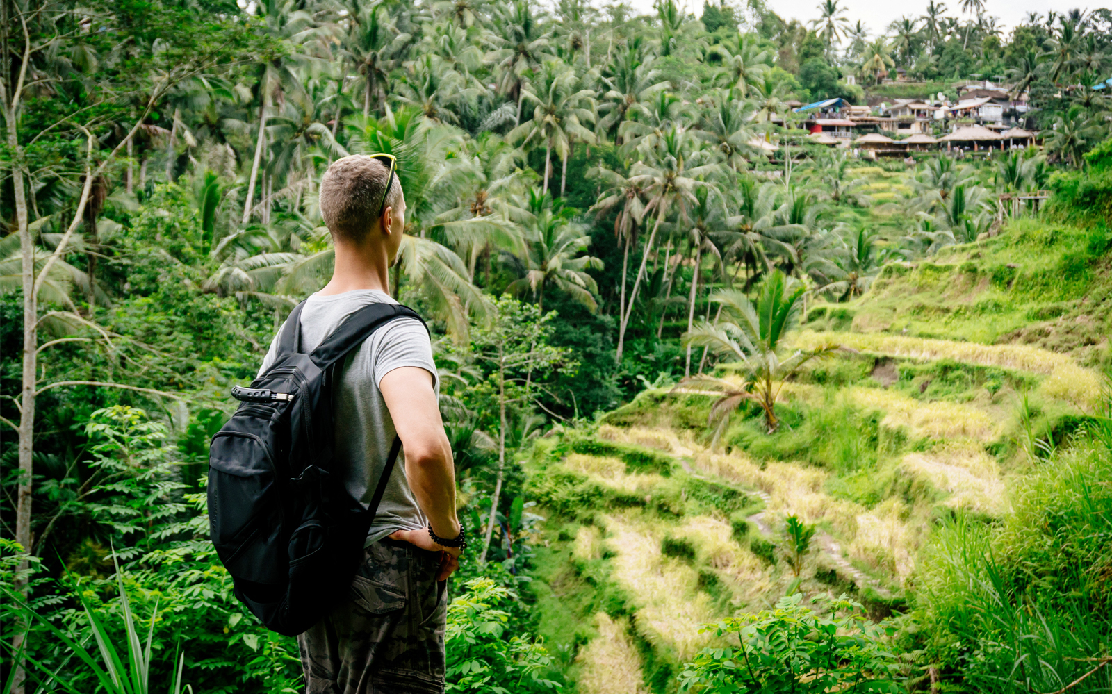 Traveler overlooking Tegalalang Rice Terraces in Ubud, surrounded by lush greenery.