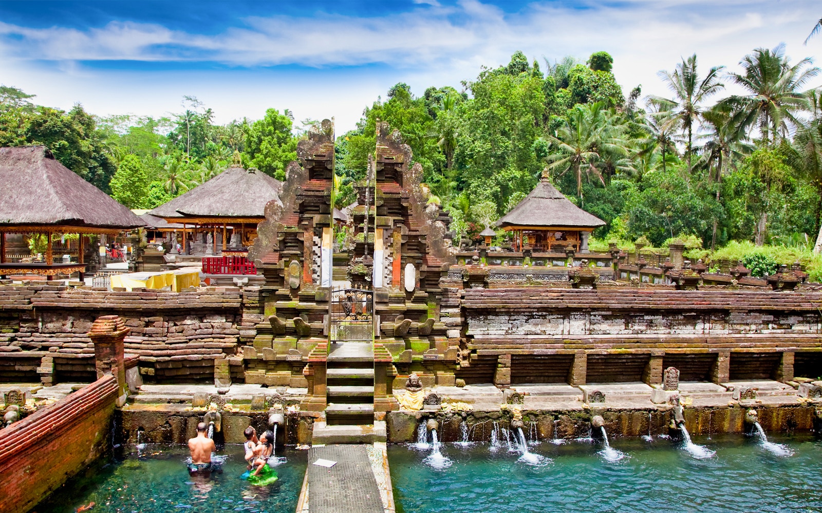 Tanah Lot Temple complex with visitors enjoying water features, Bali, Indonesia.