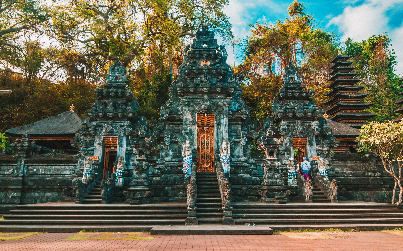 Ancient temple entrance in Tenganan Village, East Bali, surrounded by lush greenery.