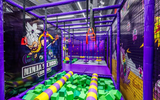 Indoor obstacle course at Kiztopia Marina Square with climbing walls and foam pit.