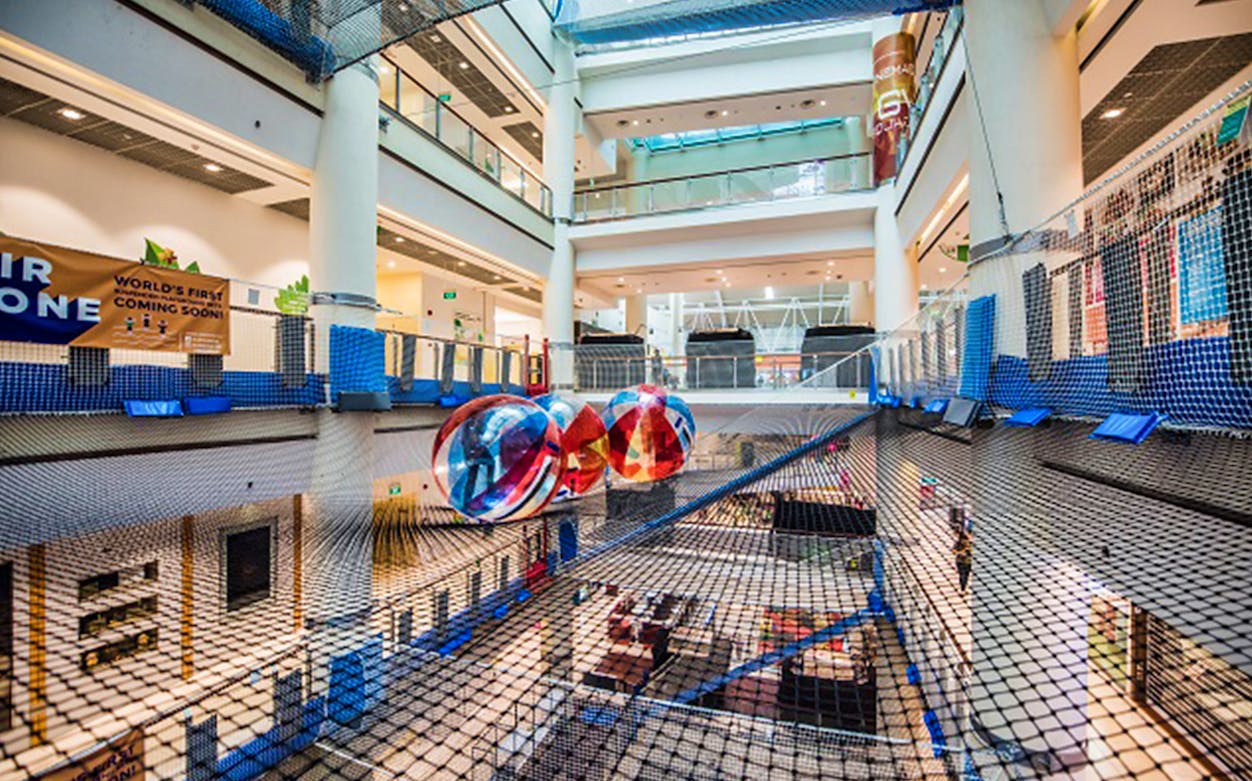 Suspended net playground with colorful spheres at Air Zone Singapore indoor attraction.