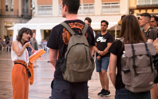 Tour guide speaking to a group during a Malaga walking tour.