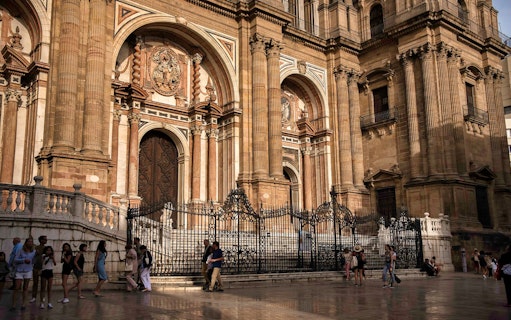 Malaga Cathedral facade with tourists during a walking tour.