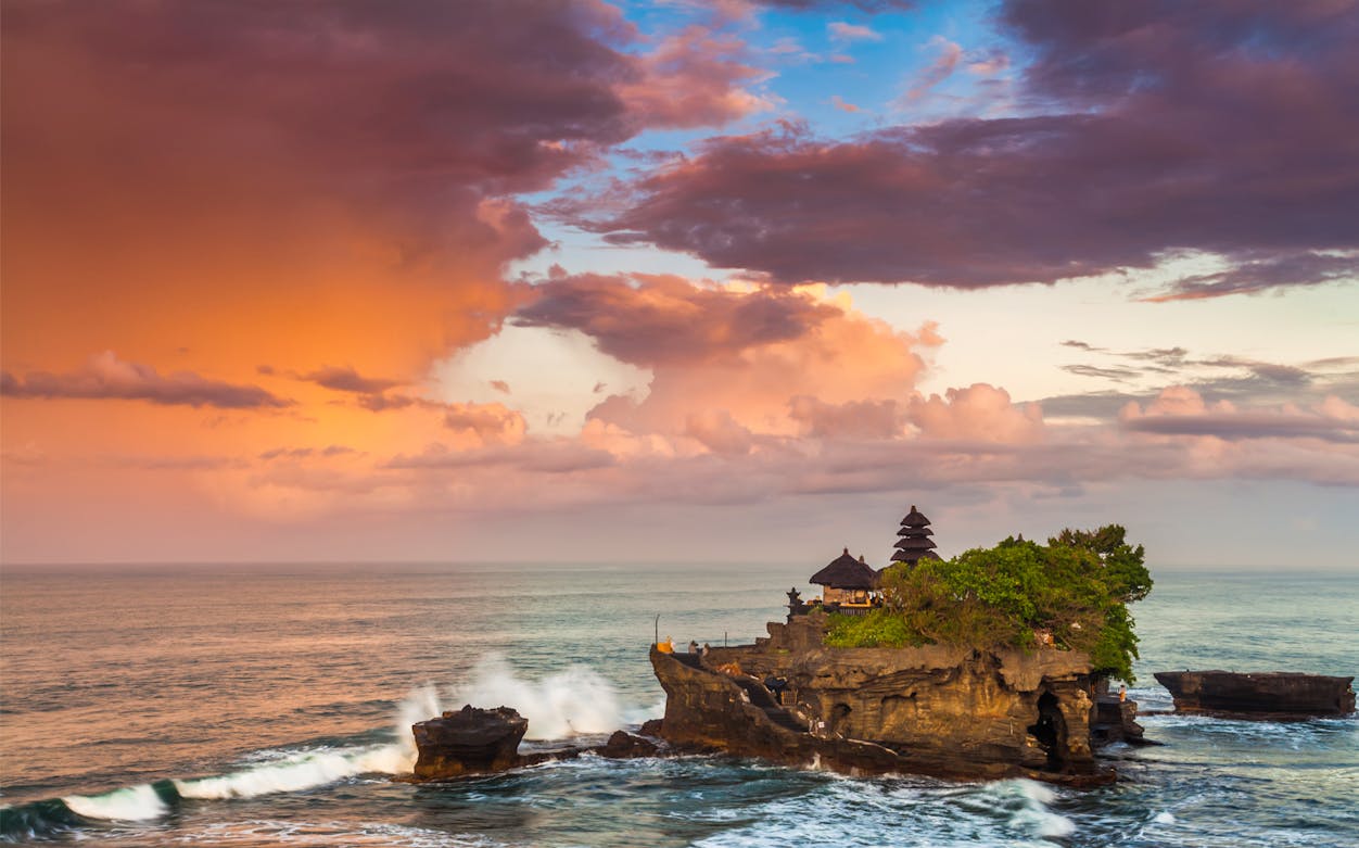 Tanah Lot Temple at sunset with ocean waves, Bali.