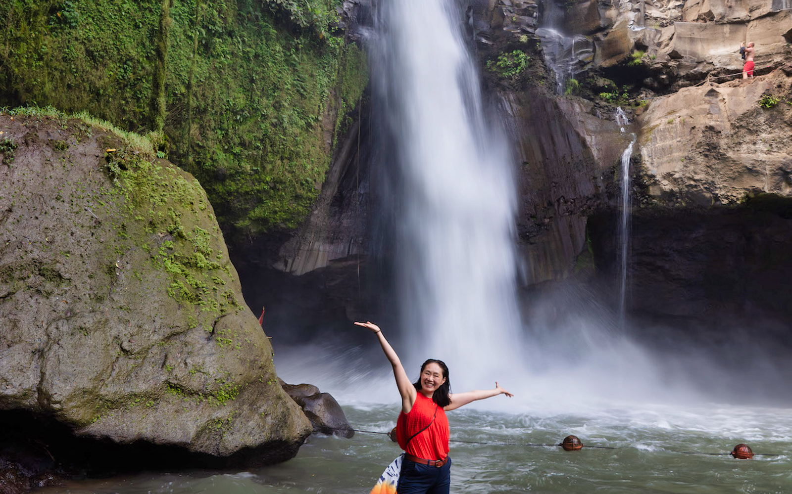 Tegenungan Waterfall with a visitor enjoying the view, Bali.
