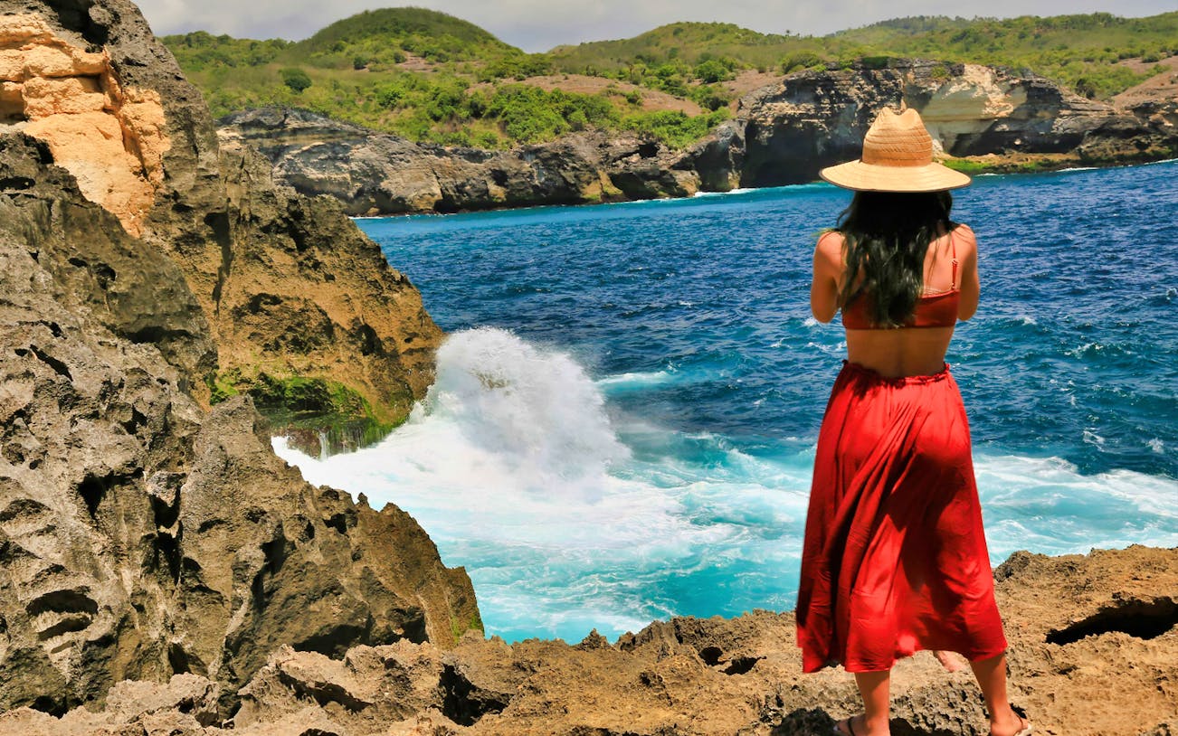 Woman overlooking ocean cliffs on West Nusa Penida during snorkeling tour.