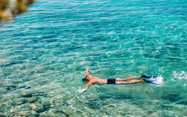 Snorkeler exploring clear waters near Japanese shipwreck in Amed, Bali.
