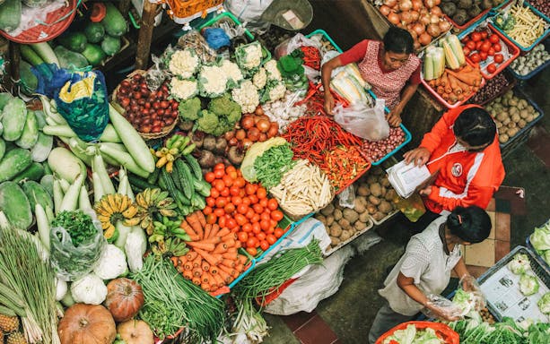 Vendors selling fresh produce at a traditional market in Denpasar, Bali.