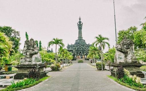 Bajra Sandhi Monument in Denpasar, Bali, with traditional statues and lush greenery.