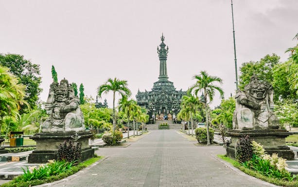 Bajra Sandhi Monument in Denpasar, Bali, with traditional statues and lush greenery.