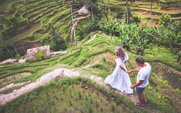 Couple walking through lush rice terraces in Bali during Instagram tour.