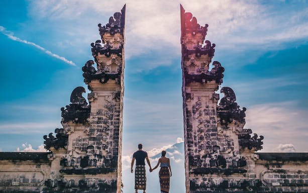 Couple holding hands at Lempuyang Temple's Gates of Heaven, Bali.