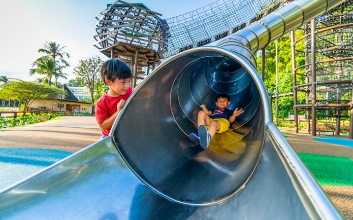 Children playing on a slide at Nestopia Singapore playground.