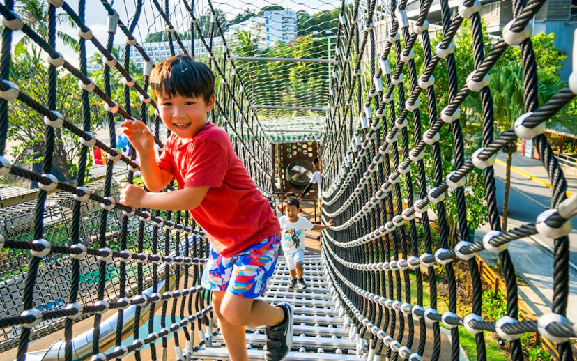Children playing on a rope bridge at Nestopia Singapore.