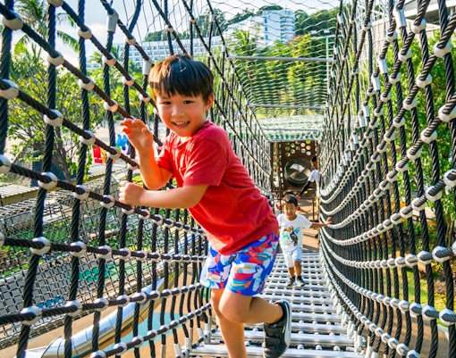 Children playing on a rope bridge at Nestopia Singapore.