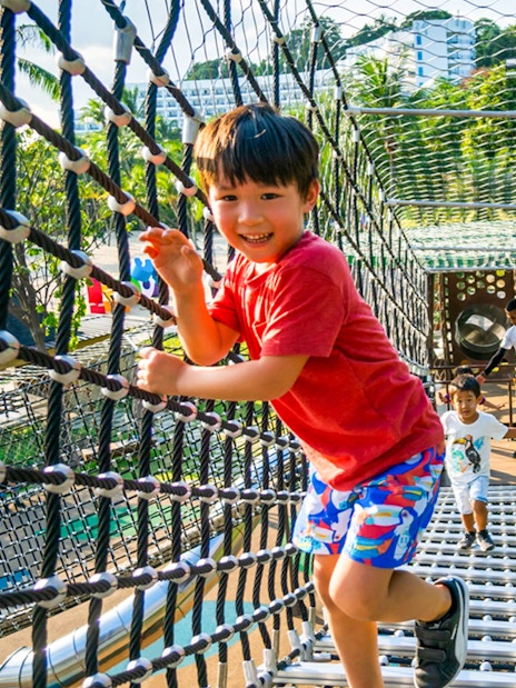 Children playing on a rope bridge at Nestopia Singapore.