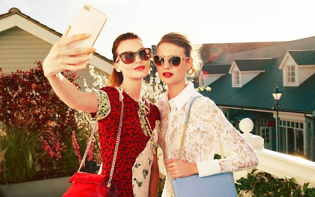 Visitors taking a selfie at Bicester Village shopping center.