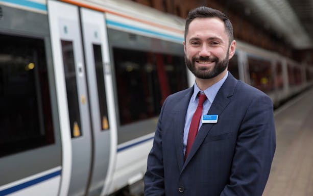 Train station staff member at platform for Bicester Village Shopping By Rail tour.