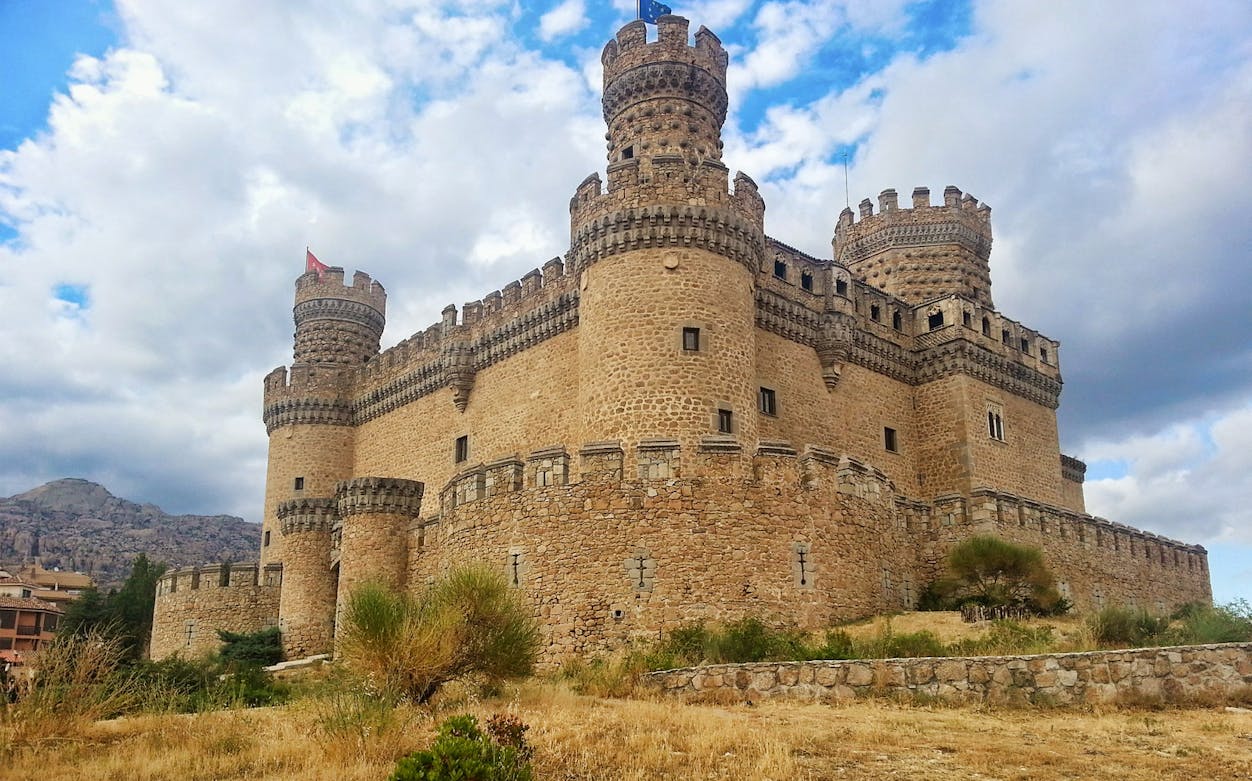 Medieval castle in Guadarrama National Park, Spain, with mountainous backdrop.