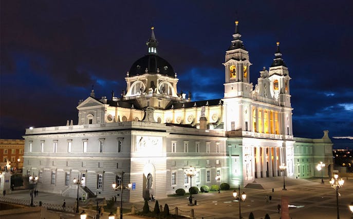 Almudena Cathedral illuminated at night, part of the Enchanted Madrid Walking Tour.