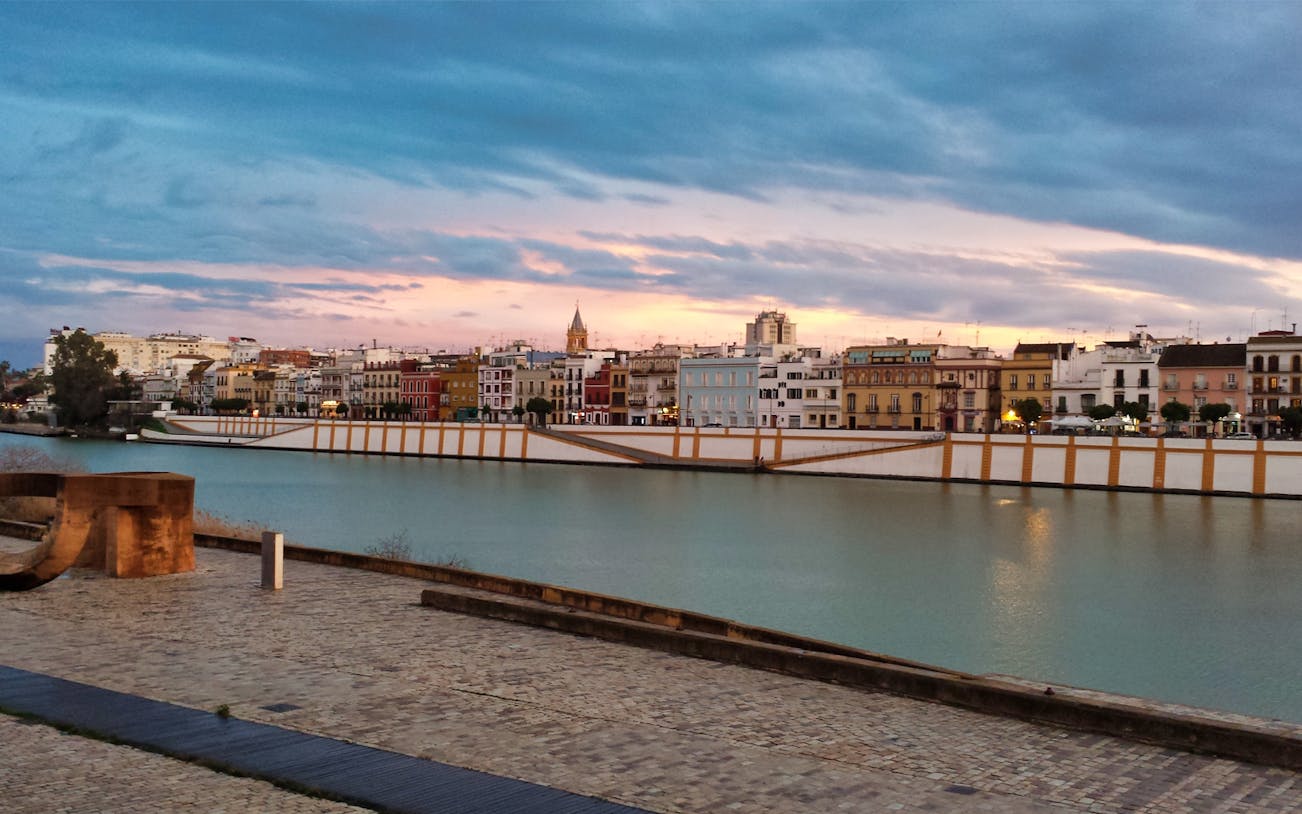 Triana district skyline at sunset, Seville, Spain, viewed from across the Guadalquivir River.