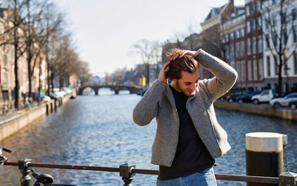 Person standing on a canal bridge in Amsterdam during the Amstagram Tour.