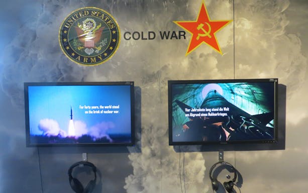 Cold War exhibit with US Army and Soviet symbols at The Wall Museum East Side Gallery.