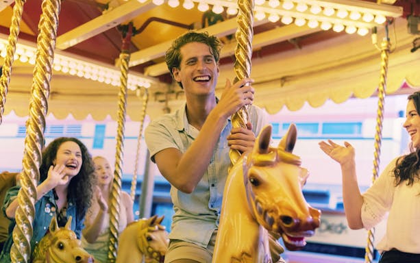 People enjoying a carousel ride at Luna Park Sydney.