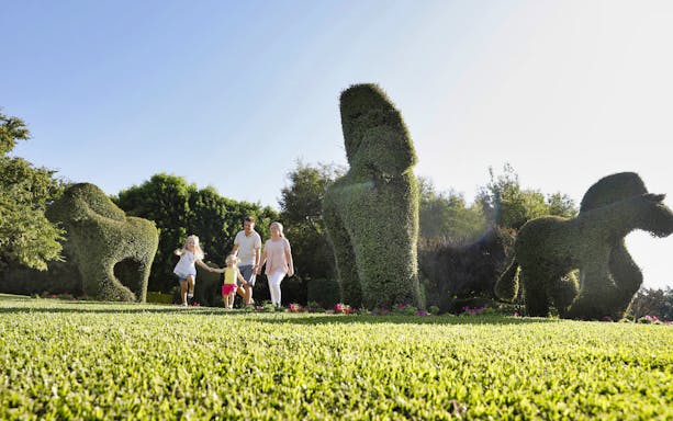 Family walking through topiary sculptures at Hunter Valley Gardens.