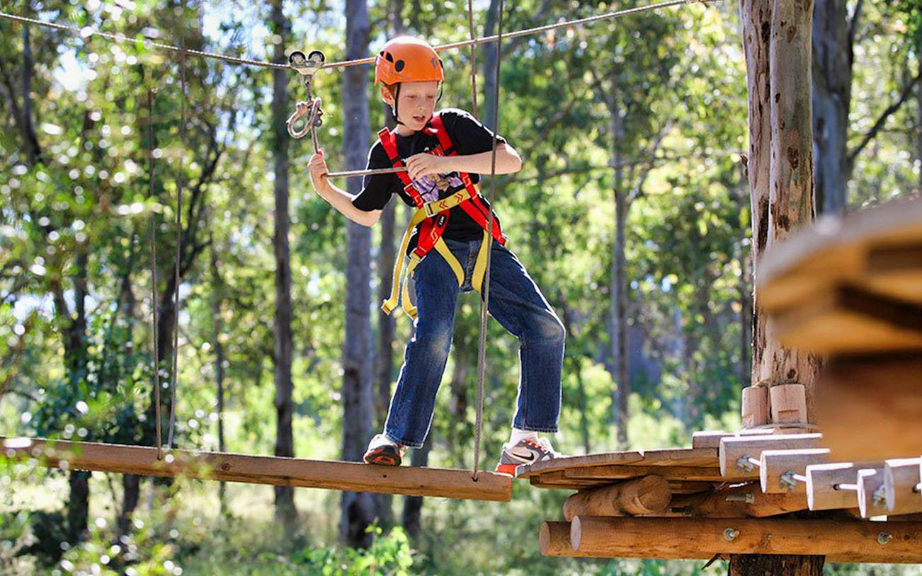 Child navigating ropes course at Treetops Adventure Park.