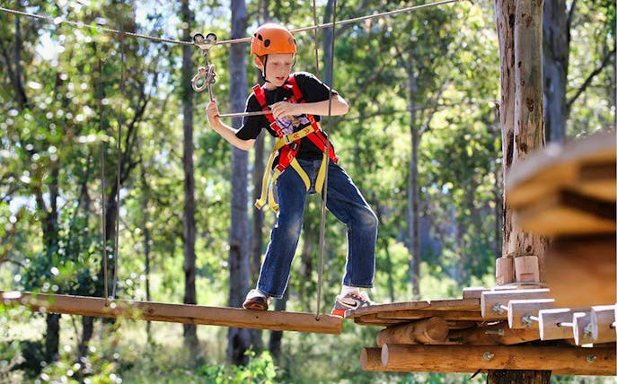 Child navigating ropes course at Treetops Adventure Park.