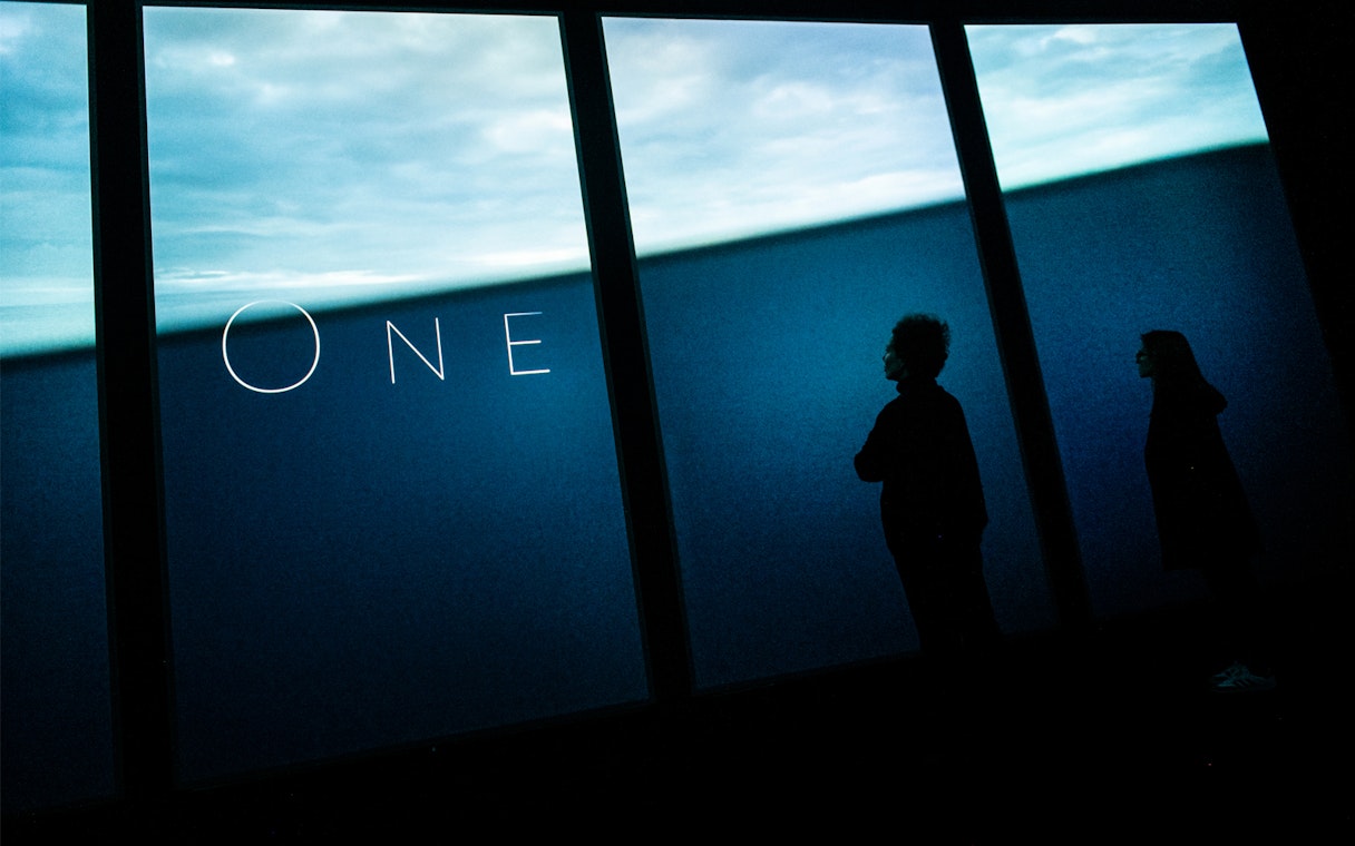 Lisboa Oceanário visitors viewing large aquarium display.