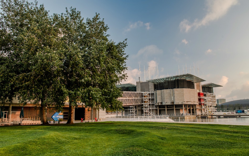 Lisboa Oceanário exterior with surrounding greenery and modern architecture.