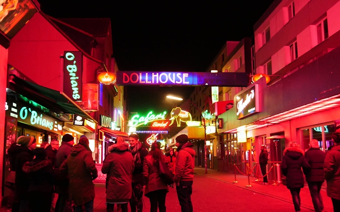 St. Pauli nightlife scene with neon signs and people on the street, Hamburg.