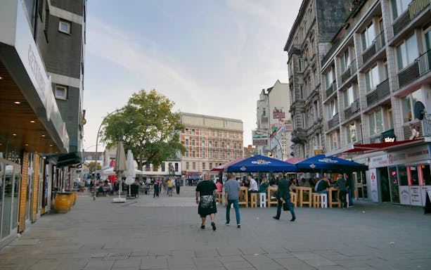 Reeperbahn street scene with people and outdoor cafes in Hamburg, Germany.