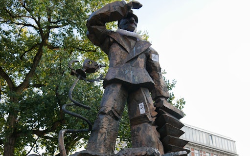 Statue on Reeperbahn tour in Hamburg, Germany, surrounded by trees.