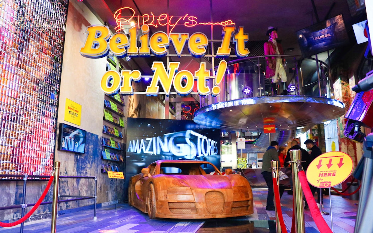 Ripley's Believe It or Not! entrance with wooden car display and neon sign.