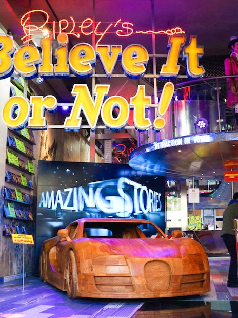 Ripley's Believe It or Not! entrance with wooden car display and neon sign.