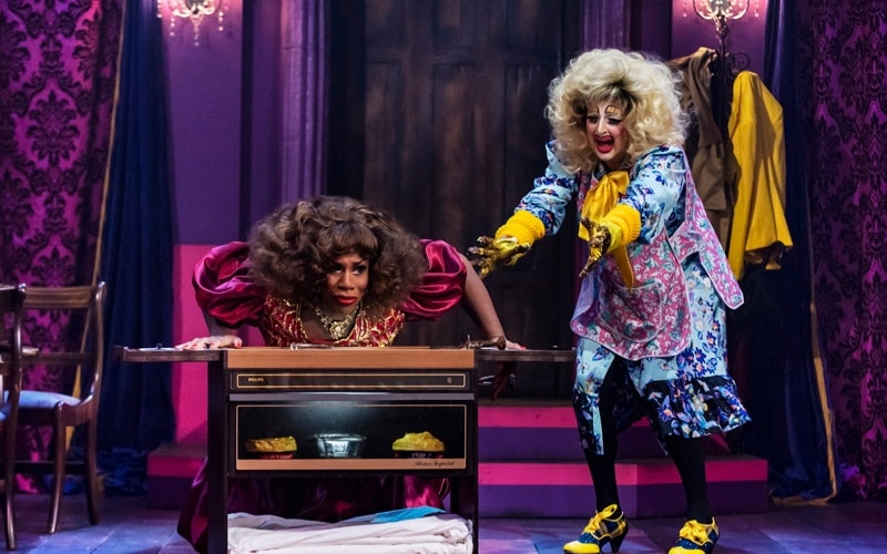 Two performers in colorful costumes on stage during "Death Drop Back in the Habit" show.