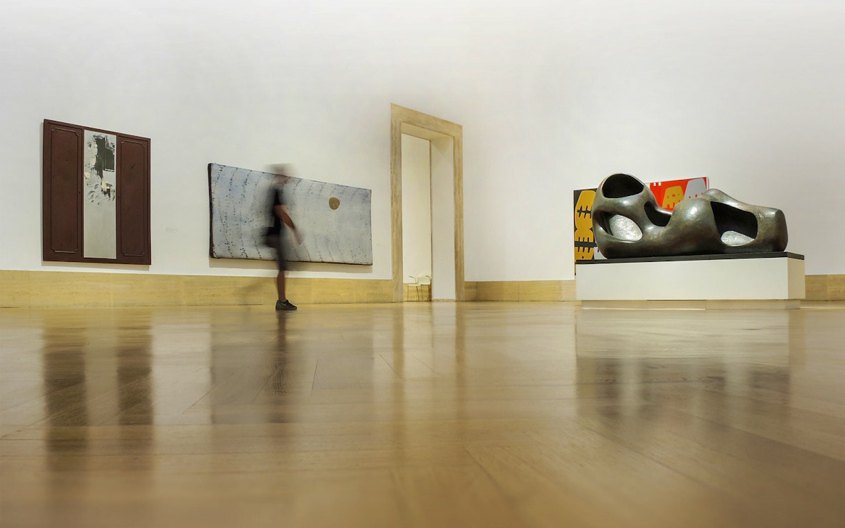 Modern art gallery interior at Palazzo Barberini, featuring abstract sculptures and paintings.
